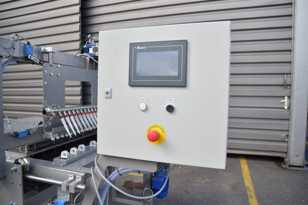 Zbliżenie na panel sterowania maszyny do produkcji podestów z żywic poliestrowych.